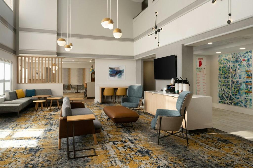 a lobby with couches and chairs and a flat screen tv at TownePlace Suites by Marriott Lafayette in Lafayette