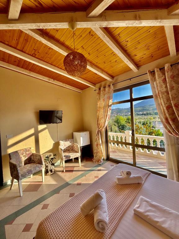 Un dormitorio con una cama y una ventana grande. en Blen Grand, en Berat