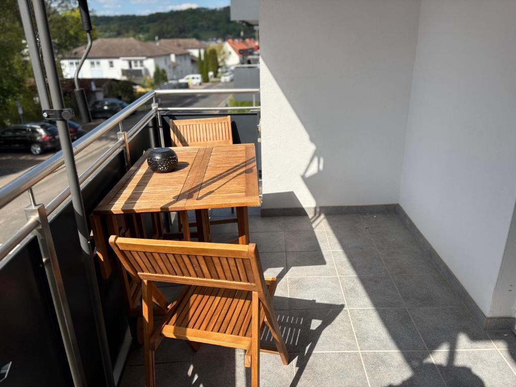 two wooden tables and chairs on a balcony at Urlaubsparadies Bad Orb in Bad Orb
