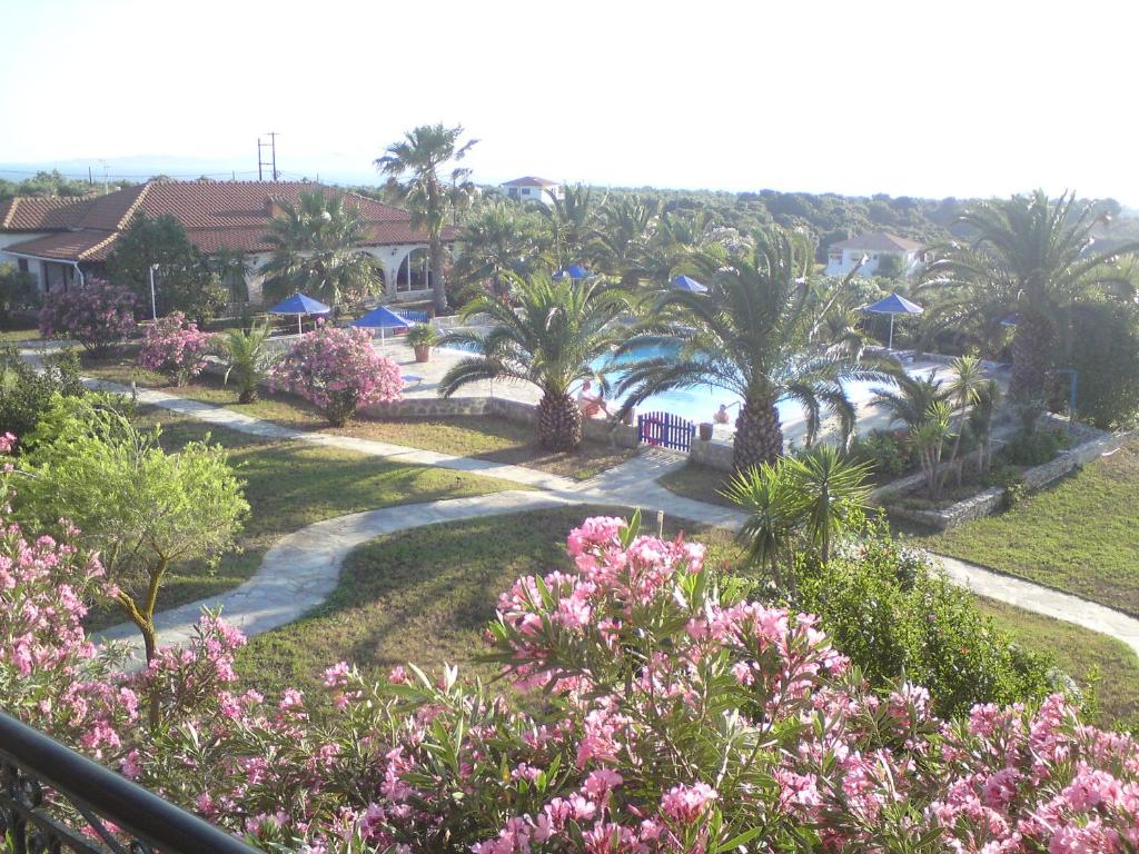 a view of a resort with palm trees and pink flowers at Helidonia in Loutra Killinis