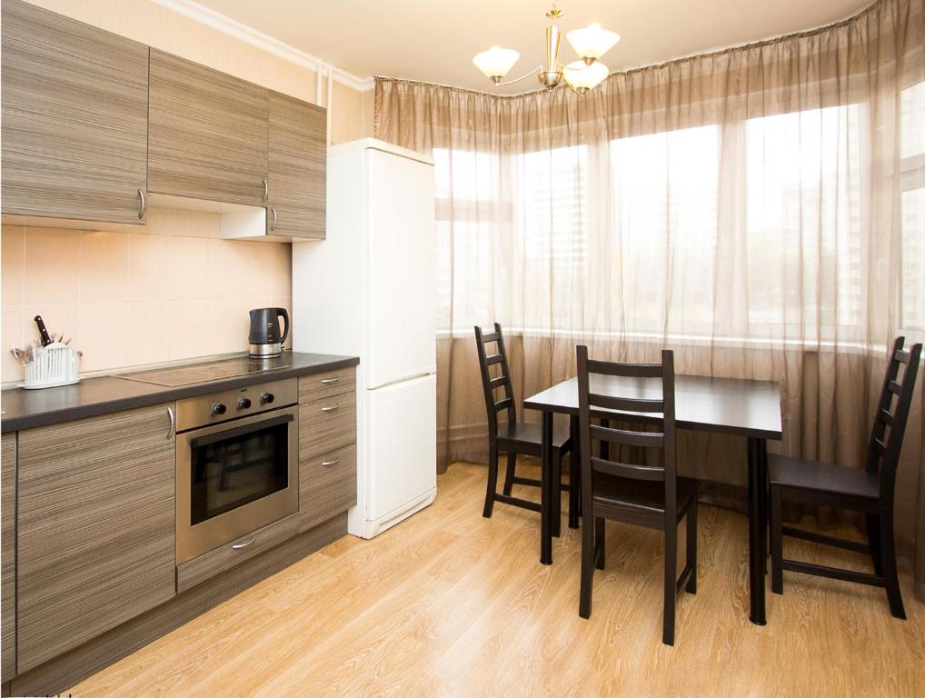 a kitchen with a table and chairs in a kitchen at ApartLux Alekseyevskaya in Moscow