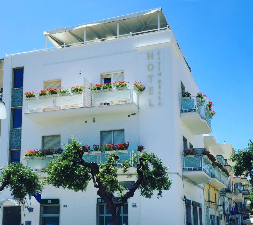 un edificio bianco con fioriere sui balconi di Hotel Città Bella a Gallipoli