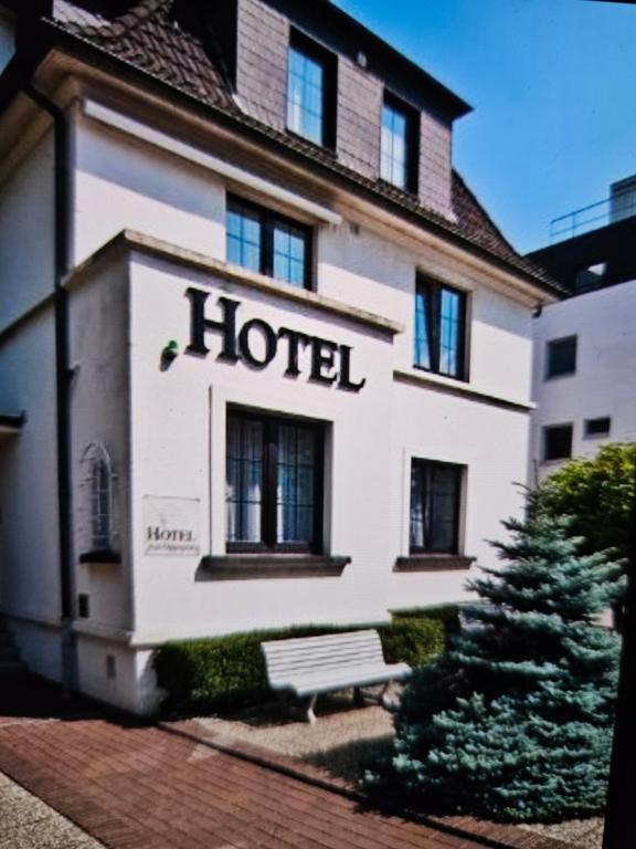 a hotel building with a bench in front of it at Hotel&Spa am Oppspring in Mülheim an der Ruhr