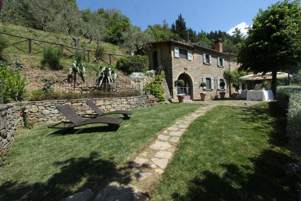 a bench sitting in the grass in front of a house at Villa Valerie in Cortona