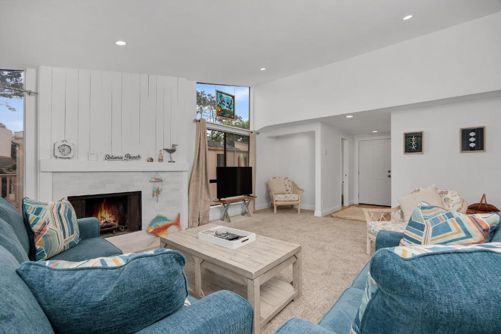 a living room with two blue couches and a fireplace at Tranquil Living - SUR4 in Solana Beach