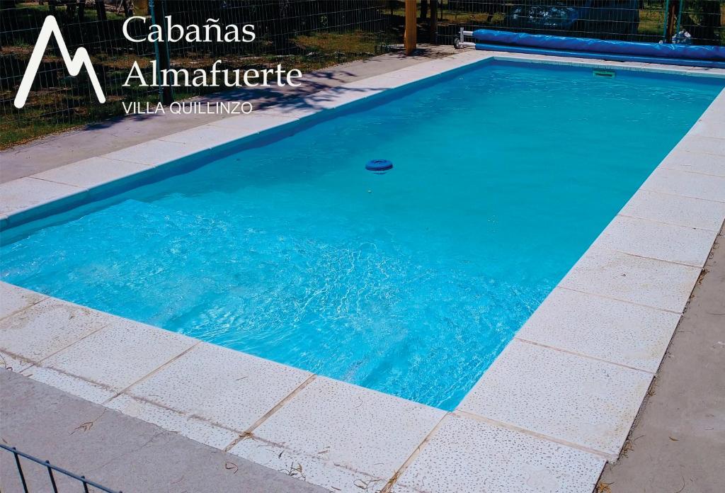 una piscina de agua azul en una acera en Cabañas Almafuerte, en Villa Quillinzo