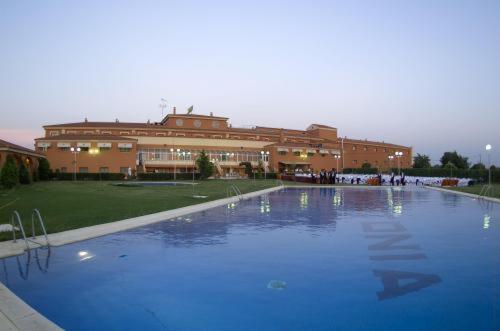 a large swimming pool in front of a building at Hotel Acosta Vetonia in Almendralejo