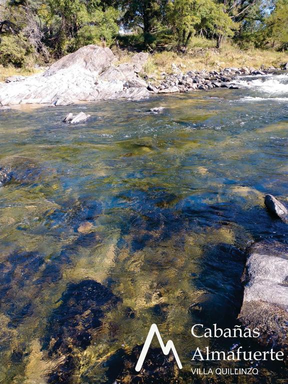 a river with rocks in the water at Cabañas Almafuerte in Villa Quillinzo