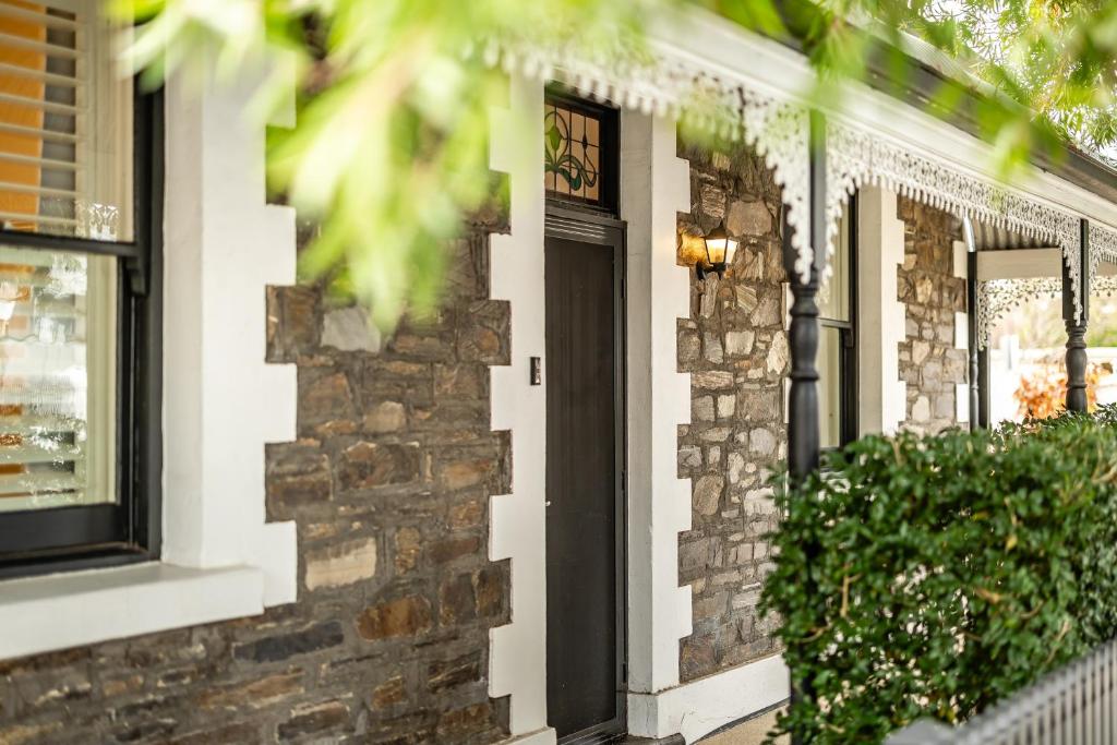 una casa de ladrillo con una puerta negra en The Goody House, en Unley