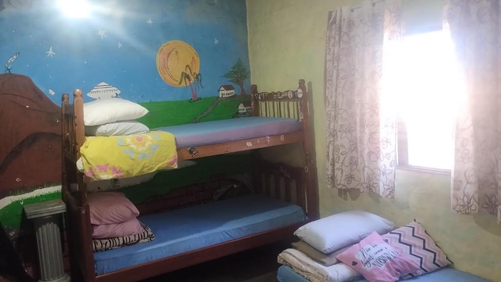 a bedroom with two bunk beds and a window at Solemarciano in São Thomé das Letras
