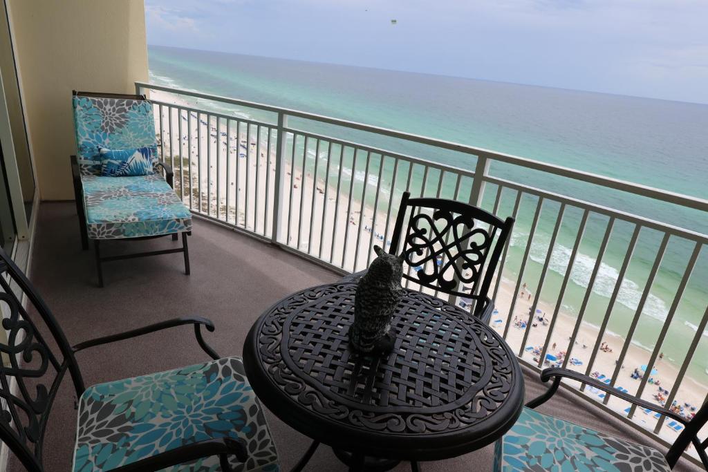 a cat sitting on a table on a balcony overlooking the beach at AQUA 1504 Beachfront condo with Free Beach Chairs in Panama City Beach