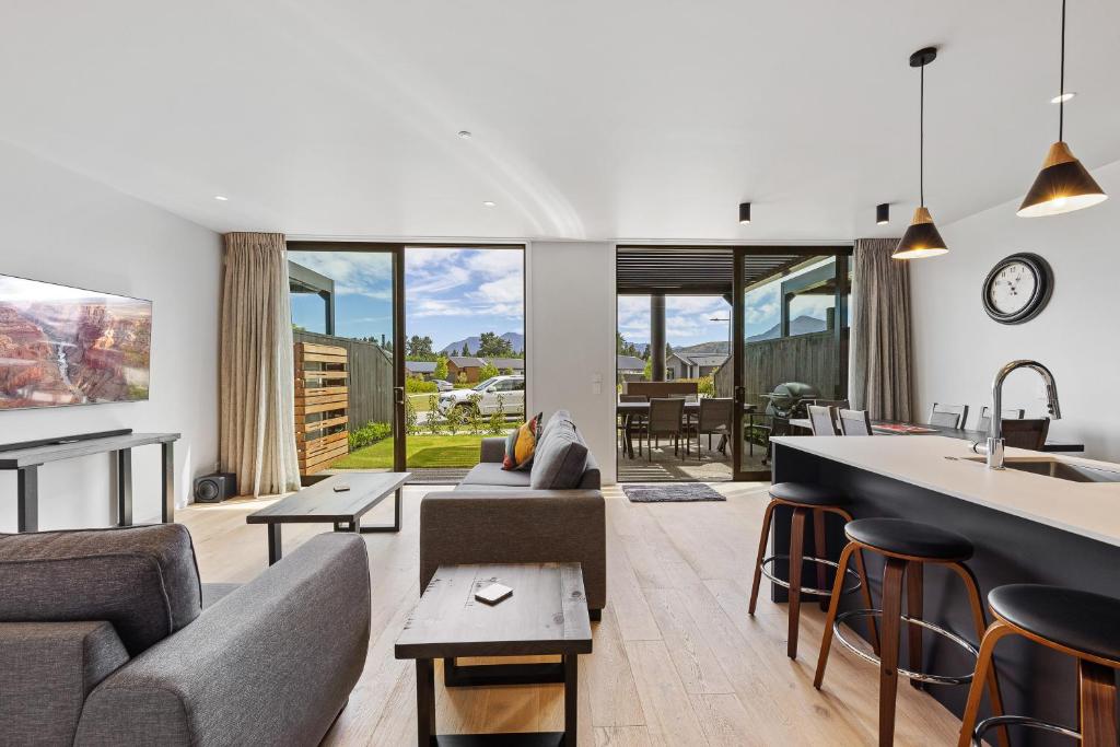 un salon avec un canapé et une cuisine dans l'établissement Luxurious Townhouse Just Minutes From Lake Wanaka, à Wanaka