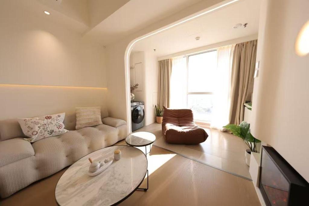 a living room with a couch and a table at Shanghai Hills & Wanda Side Spacious Stay Close to Metro Line 18 in Shanghai