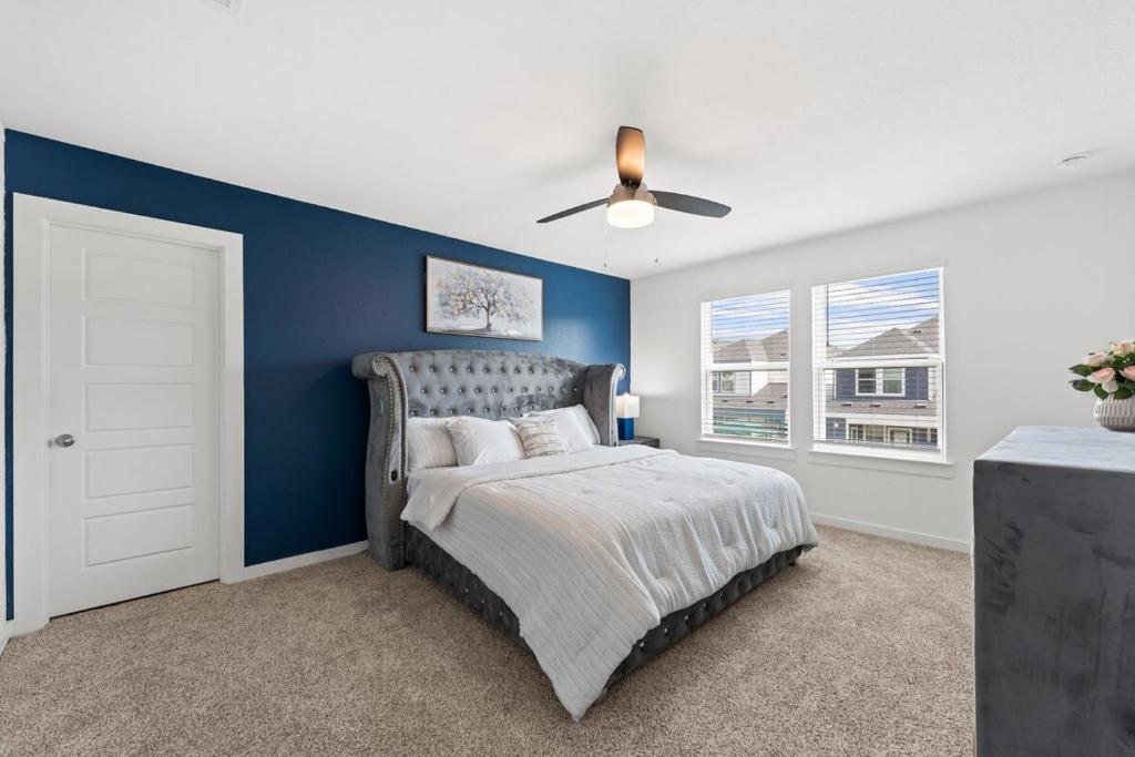 1 dormitorio con paredes azules y 1 cama con ventilador de techo. en Cozy home away from home, en Houston