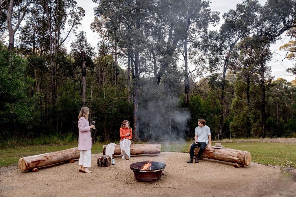 a group of people standing around a fire pit at Weetaliba - Country Retreat in Yatte Yattah