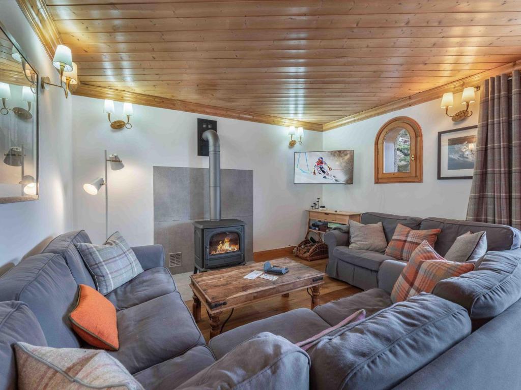 un salon avec un canapé et une cheminée dans l'établissement Chalet Méribel 8 pers, ski-in/ski-out, 4 ch, WIFI - FR-1-565-117, à Les Allues