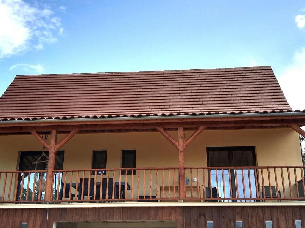 Cette maison dispose d'un balcon avec un toit marron. dans l'établissement Maison neuve à Sarlat avec jardin et terrasse - FR-1-616-488, à Sarlat-la-Canéda
