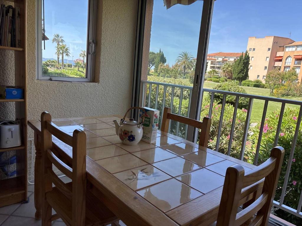 une table de salle à manger avec vue sur un balcon dans l'établissement Appartement 2 pièces cabine, proche plage, animaux acceptés - FR-1-826-16, à La Londe-les-Maures