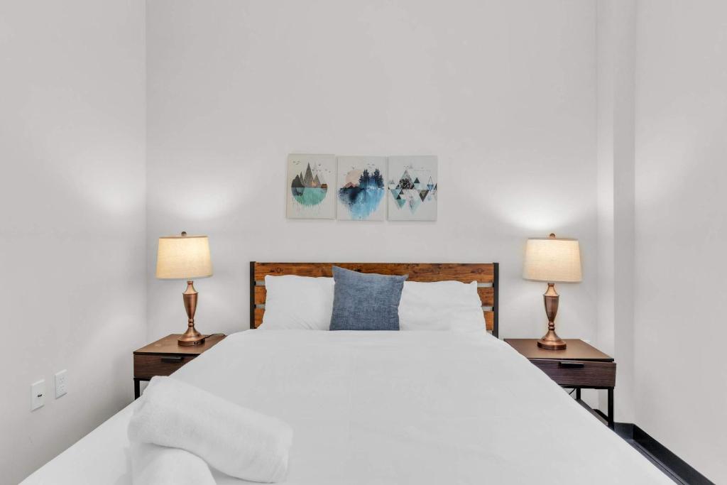 a bedroom with a large white bed with two lamps at CozySuites Modern 1BR in Downtown Pitts #22 in Pittsburgh