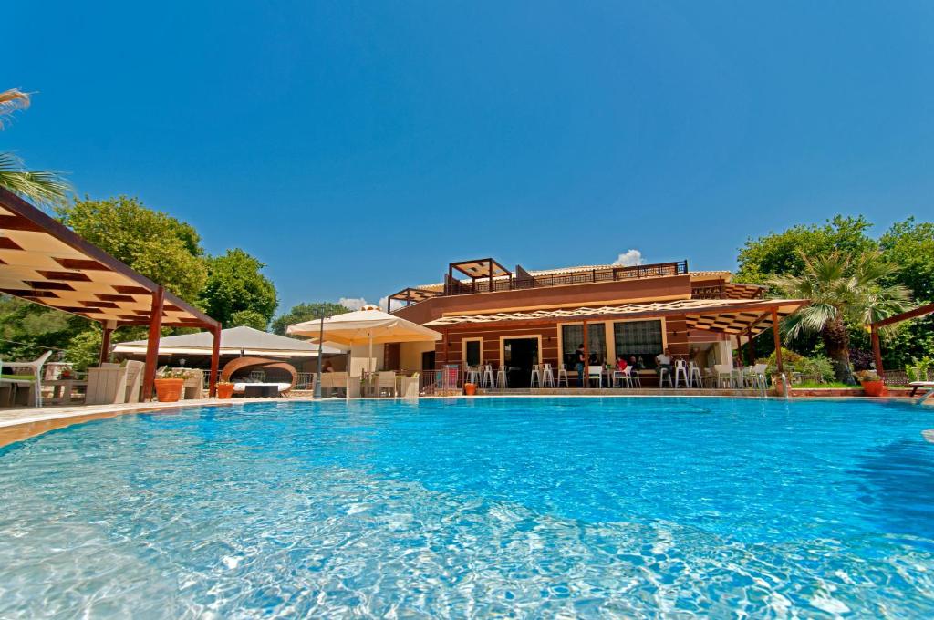 a large swimming pool in front of a house at Riviera Perdika Hotel in Perdika