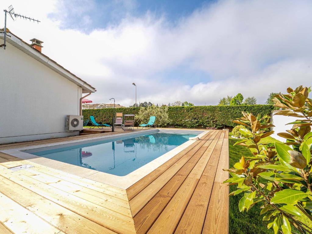 a swimming pool with a wooden deck next to a house at Maison à Mimizan avec jardin et piscine privée pour 6 personnes - FR-1-50-95 in Mimizan