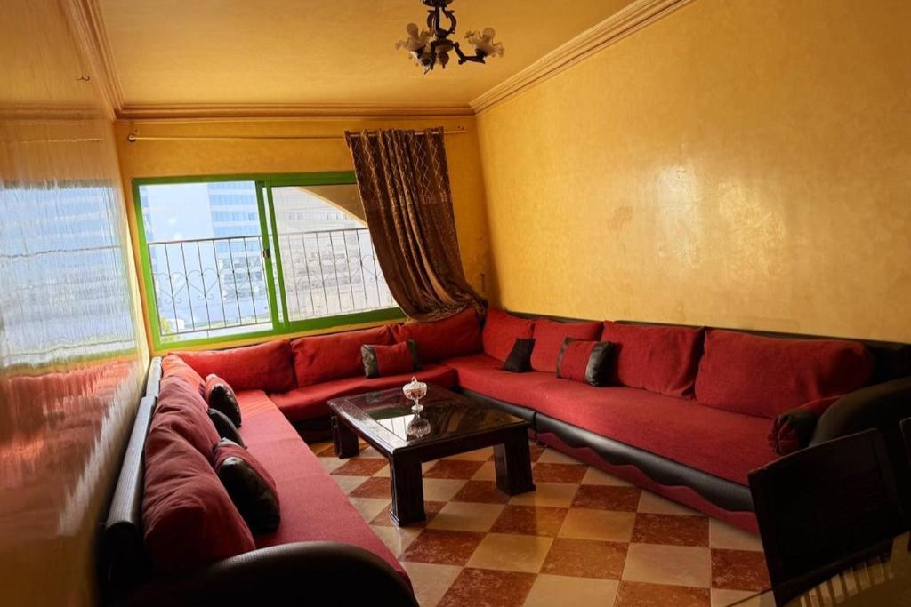a living room with a red couch and a table at Luxury apartment in front of the Corniche in Tangier