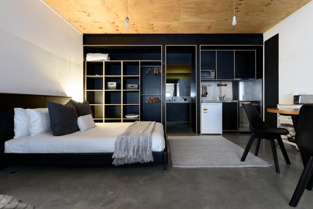 Bright Studio in Launceston CBD في Kings Park: غرفة نوم بها سرير ومكتب ومطبخ