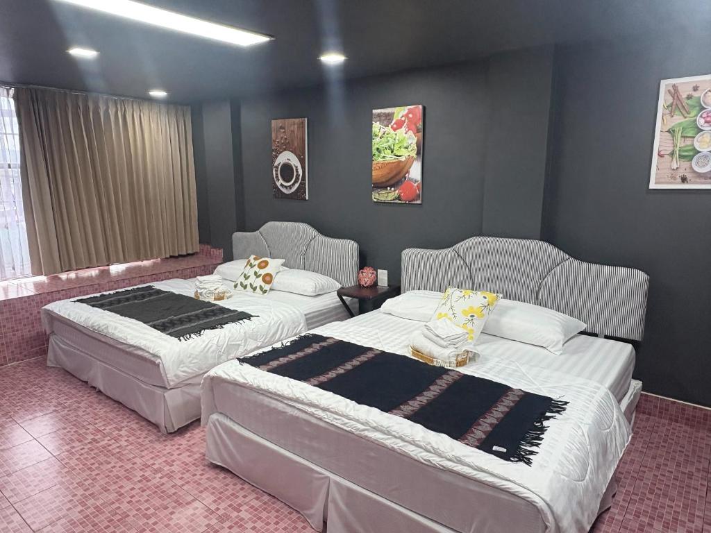 two beds in a room with two chairs at Destiny House Hostel in Hat Yai