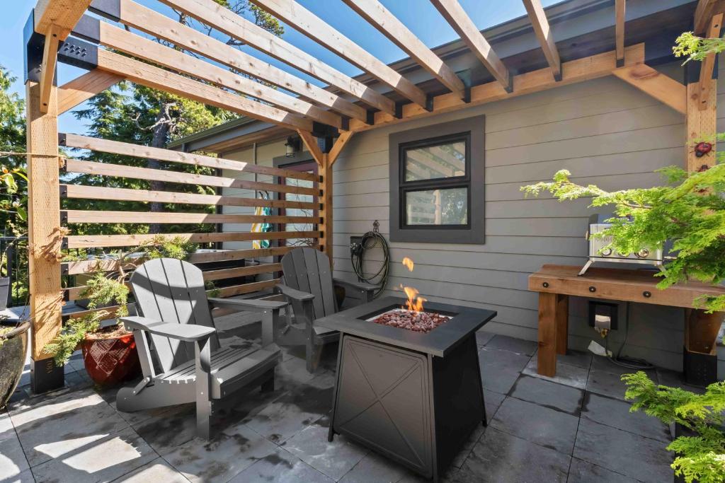 eine Terrasse mit Tisch und Stühlen sowie einer Feuerstelle in der Unterkunft Suite Ucluelet - Romantic Couples Getaway-Sauna! in Ucluelet