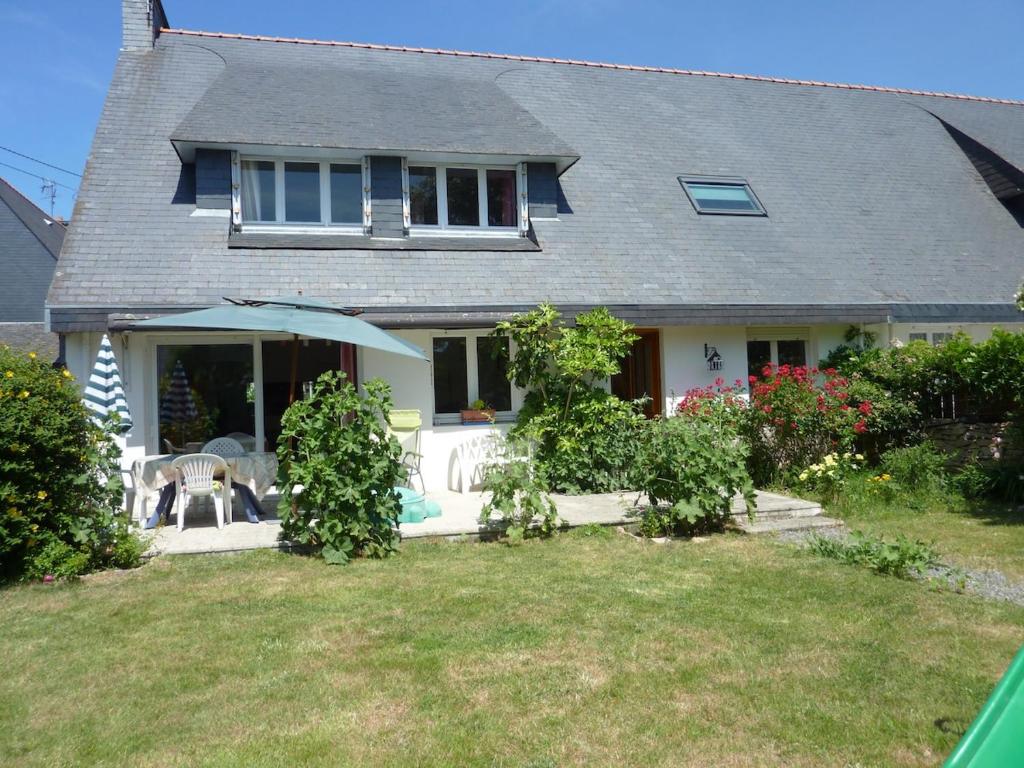 a house with an umbrella on a yard at Maison T3 avec jardin 5 minutes de Vannes in Saint-Avé