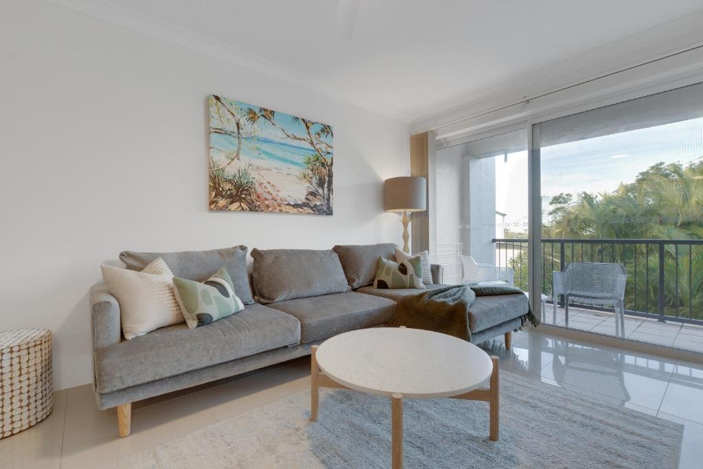 a living room with a couch and a table at 2 BR Coastal Bliss Opposite Currumbin Beach in Gold Coast