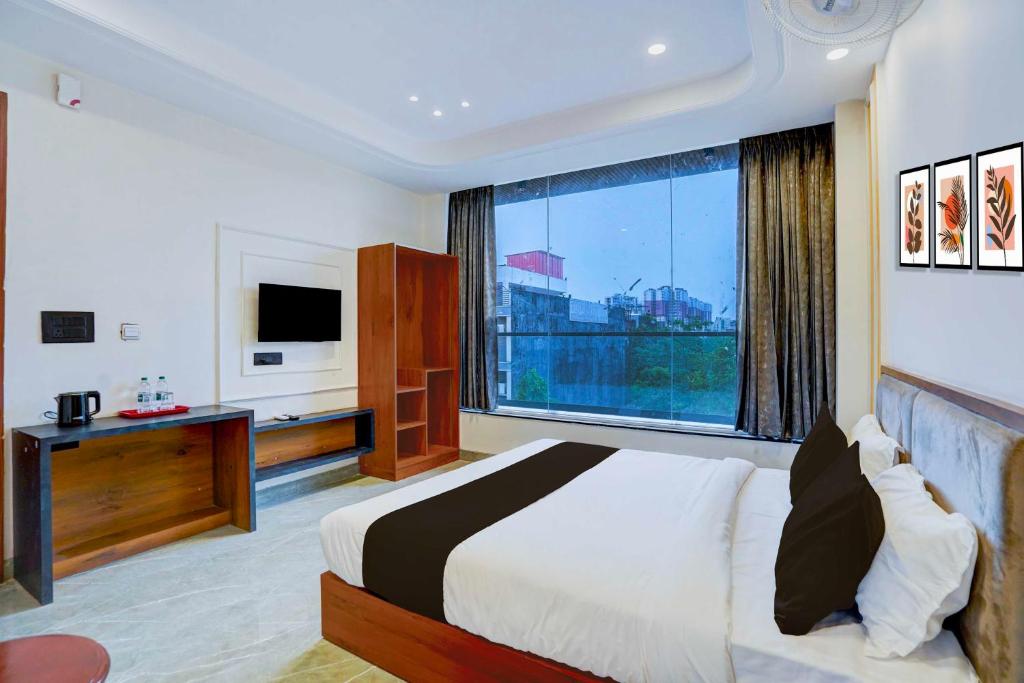 a hotel room with a bed and a large window at Collection O Expo Mart Ansal Golf Link 1 in Noida