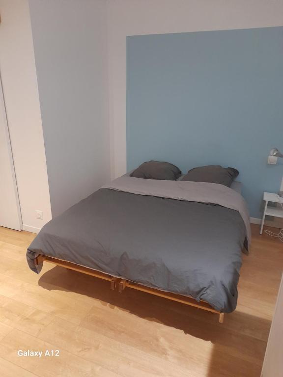 Cette chambre comprend un grand lit et du parquet. dans l'établissement Appartement indépendant Broceliande, à Saint-Thurial