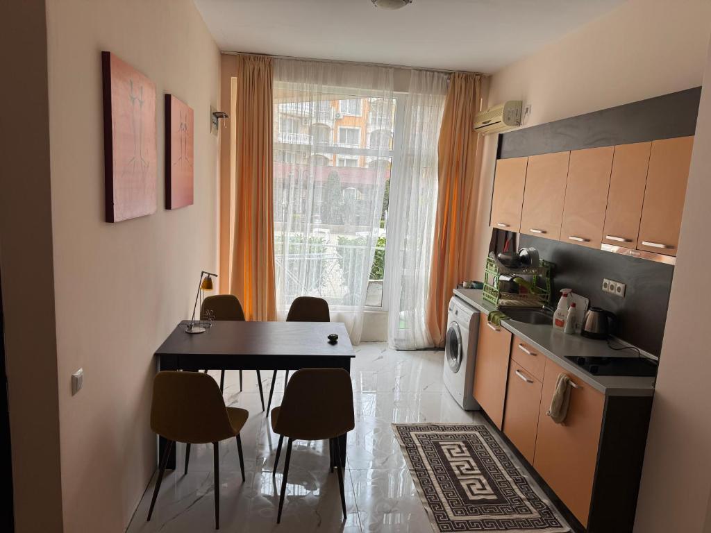 a kitchen with a table and chairs in a room at Центр солнечного берега in Sunny Beach