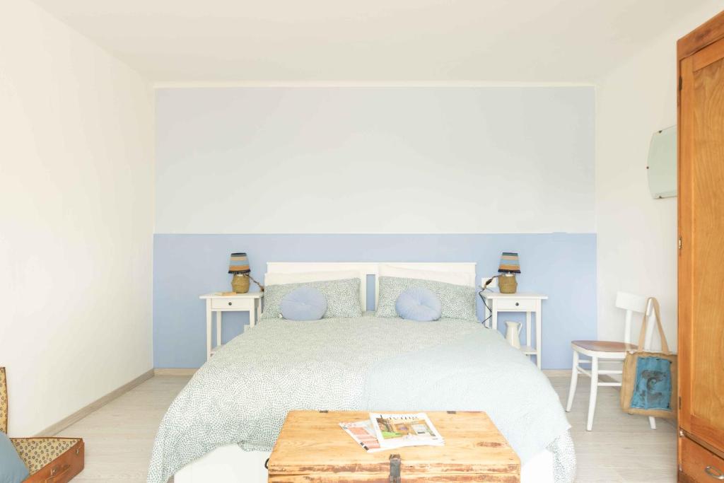 a bedroom with a bed with a wooden table at VITEDIMARE APARTMENT SABBIA - SAND in Muggia