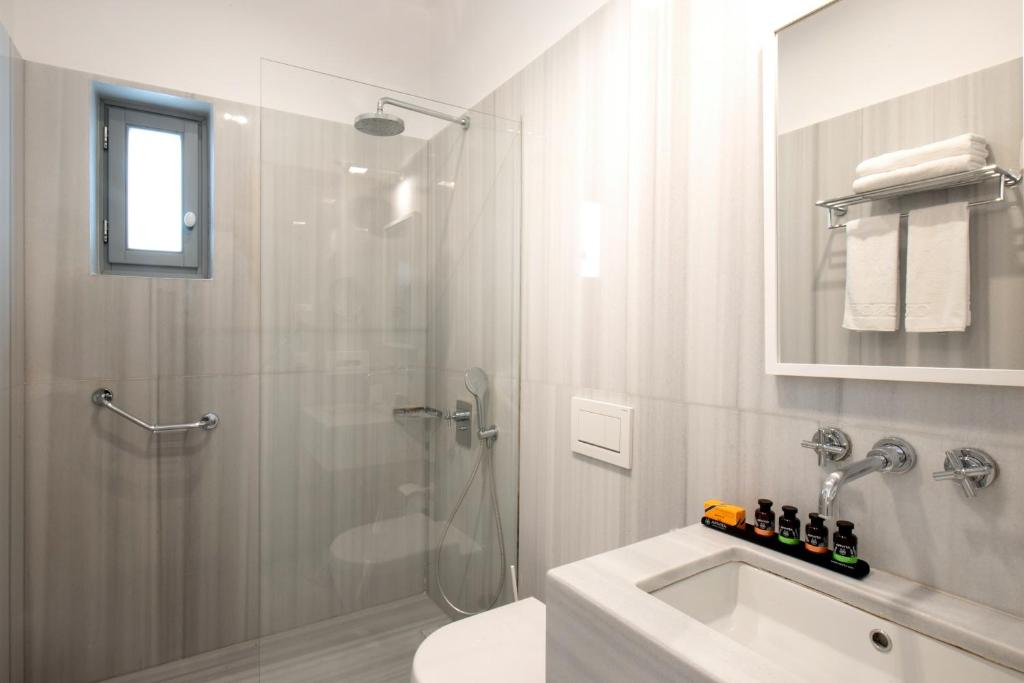a bathroom with a shower and a toilet and a sink at Orloff Resort in Spetses