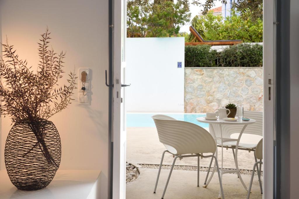 a room with a table and chairs and a vase at Orloff Resort in Spetses
