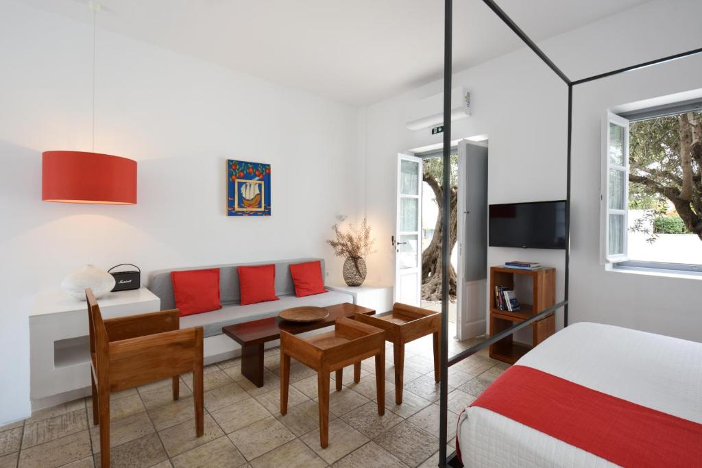 a bedroom with a bed and a table and chairs at Orloff Resort in Spetses