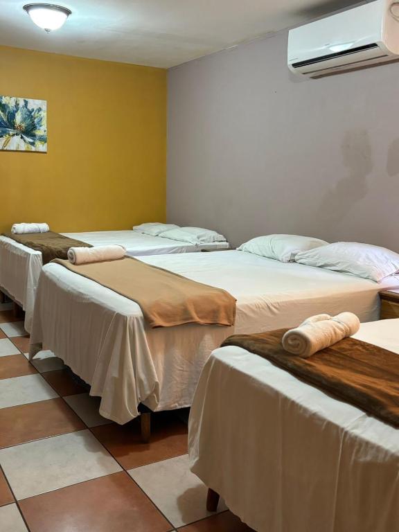 a group of four beds in a room at Hotel Lima Park in La Lima
