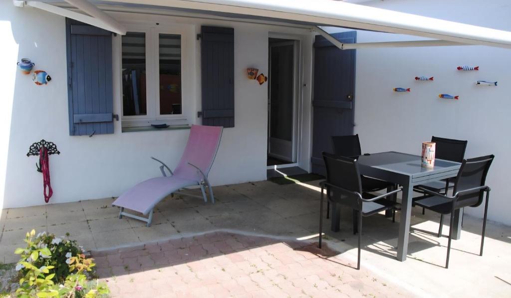 une terrasse avec une table et des chaises dans une maison dans l'établissement Topette, à Barbâtre