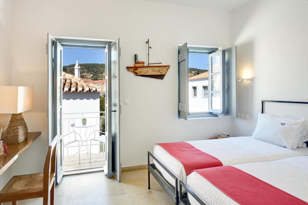 a bedroom with two beds and a balcony at Orloff Resort in Spetses