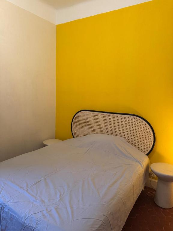 - une chambre avec un lit et un mur jaune dans l'établissement Lovely villa with pool in Arles, à Arles