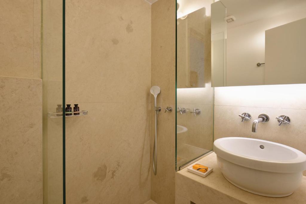 a bathroom with a sink and a glass shower at Orloff Resort in Spetses