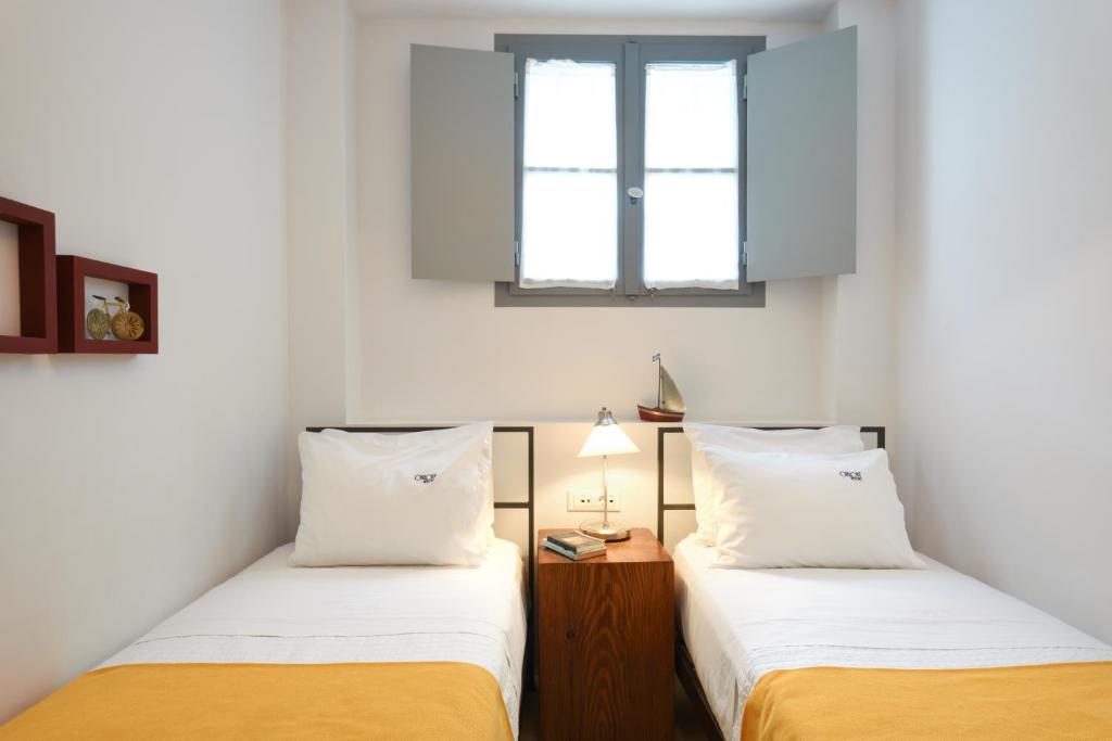 two beds in a room with two windows at Orloff Resort in Spetses