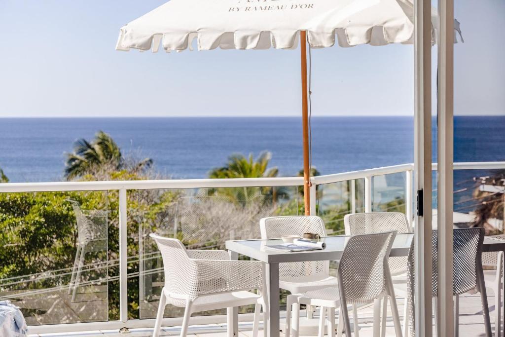 a table and chairs on a balcony with the ocean at Hydra - 3 Bedrooms, Ocean views, Pool in Sunshine Beach