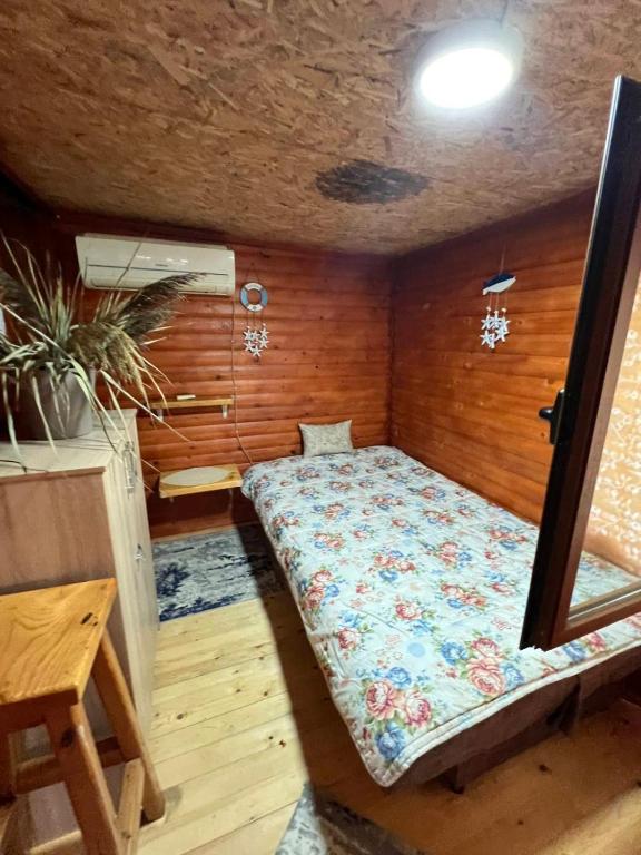 łóżko w pokoju z drewnianą ścianą w obiekcie Vanilla House w Ulcinju