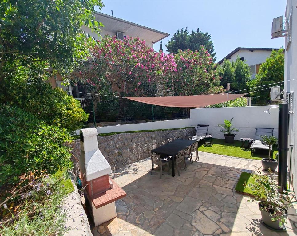 a patio with a table and chairs and a fence at Villa Helena Rovanjska in Rovanjska