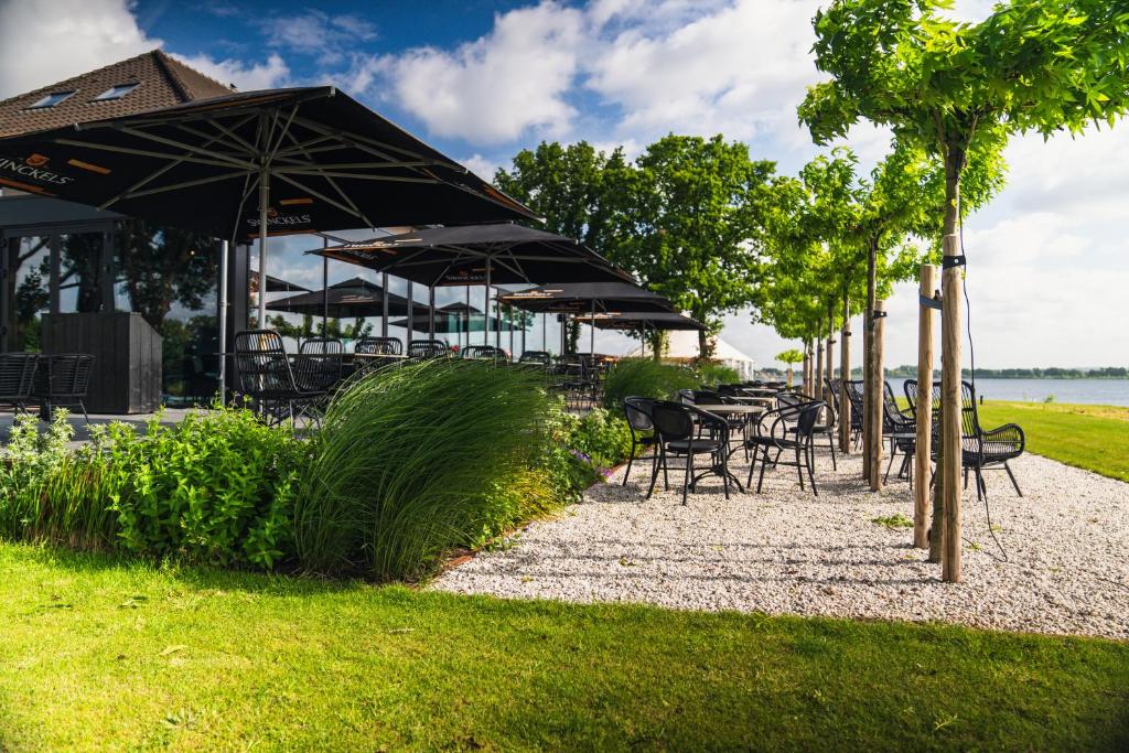 a row of tables and chairs with umbrellas at Boutique Hotel de Bungelaer in Beers