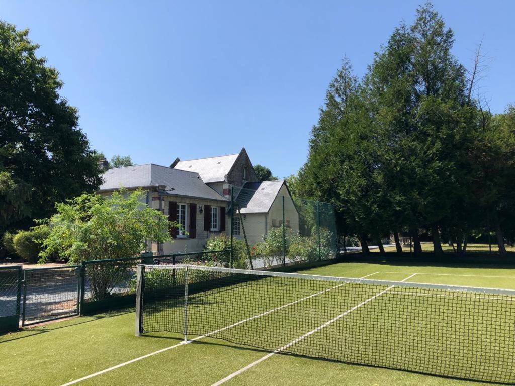 un court de tennis devant une maison dans l'établissement Petit manoir av court de tennis, à Amayé-sur-Orne