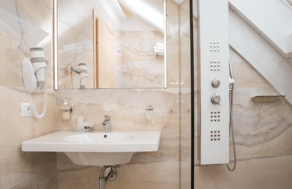 a bathroom with a sink and a mirror at Hotel Ambassador in Rimini